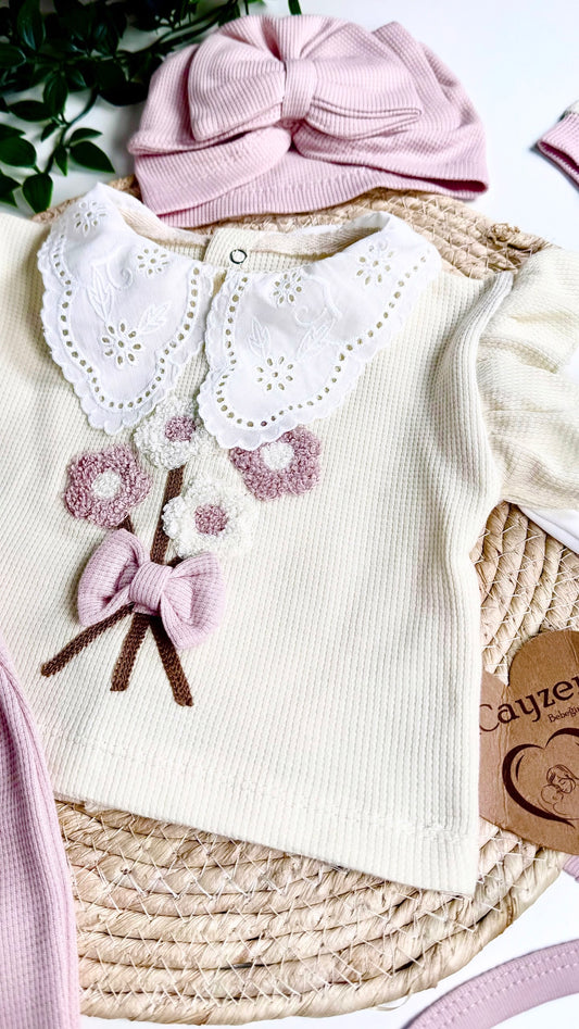 Nouveau-né portant un ensemble naissance fille en coton bio rose poudré et crème, confort et élégance dès la maternité